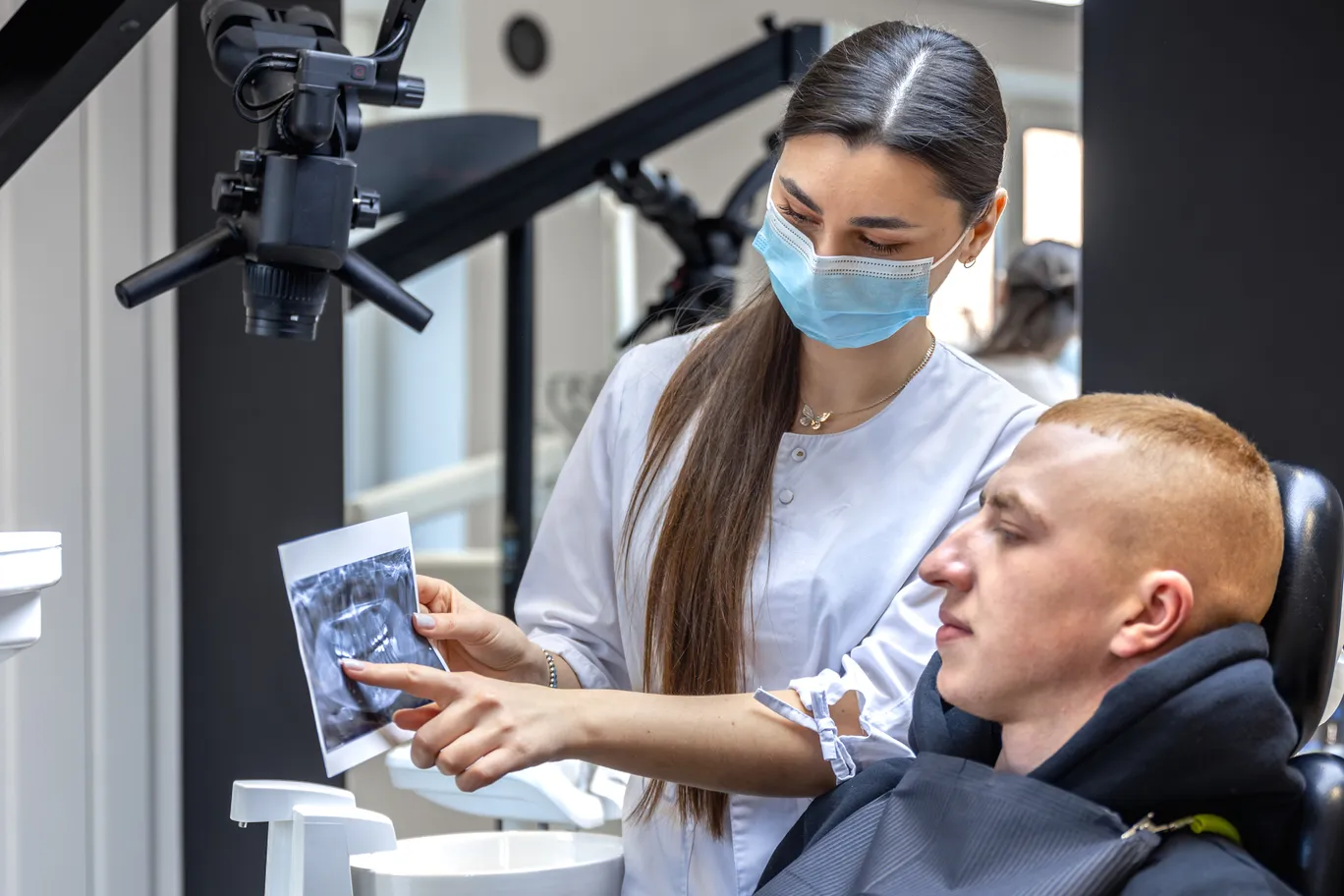 young-female-dentist-showing-patient-dental-xray-dentistry-concept (2) (1).jpg