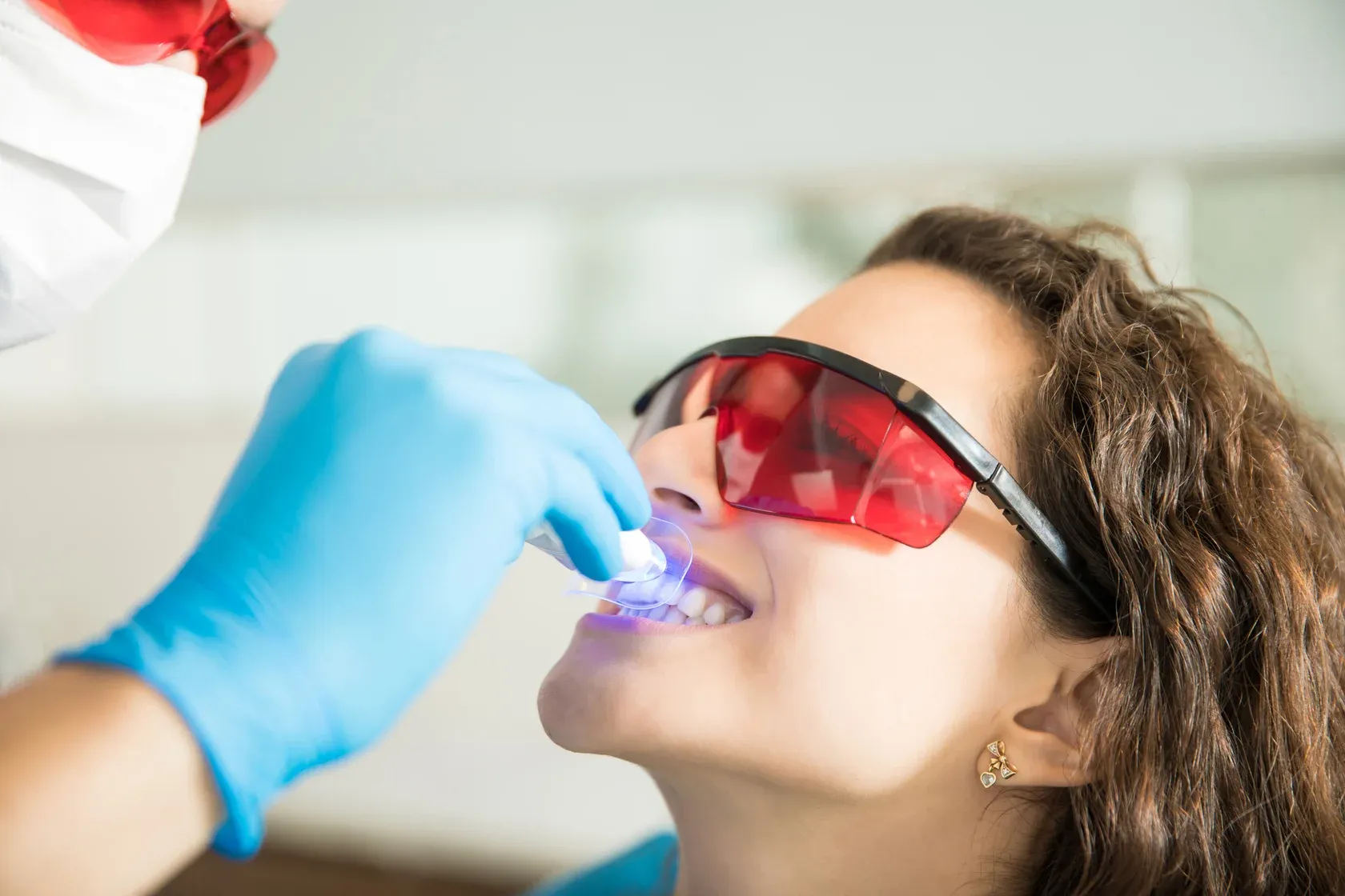 closeup-young-woman-having-her-teeth-whitened-with-ultraviolet-light-dental-clinic (1).webp