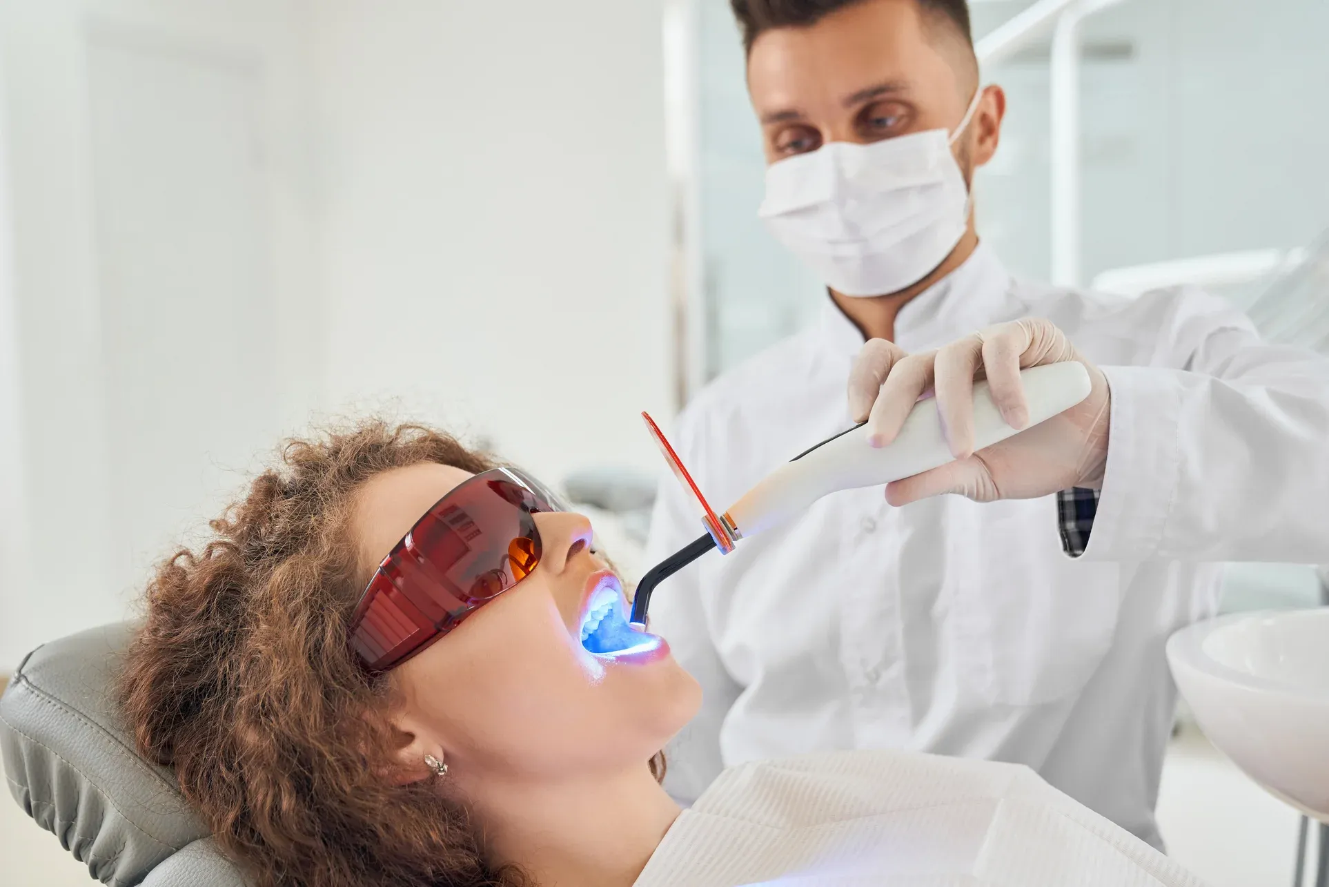 girl-lying-chair-while-dentist-keeping-ultraviolet-tool (1).webp